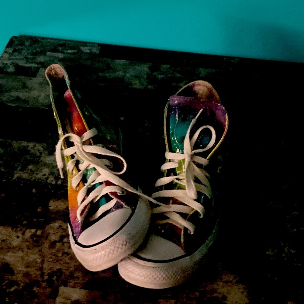 Tie died shoes with the bottom torn up worn a lot